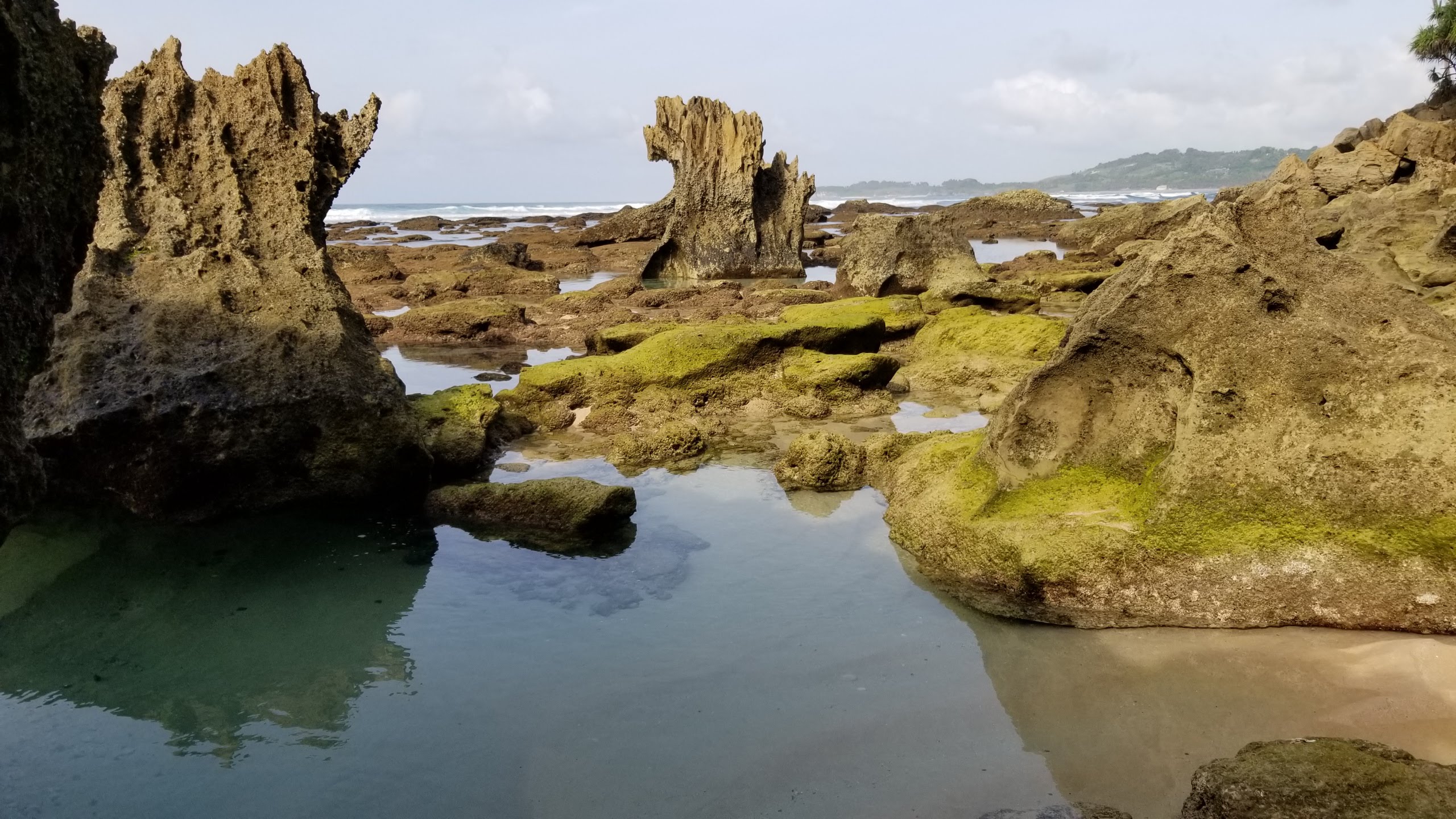 Water pools by the rock formations at the end of the beach