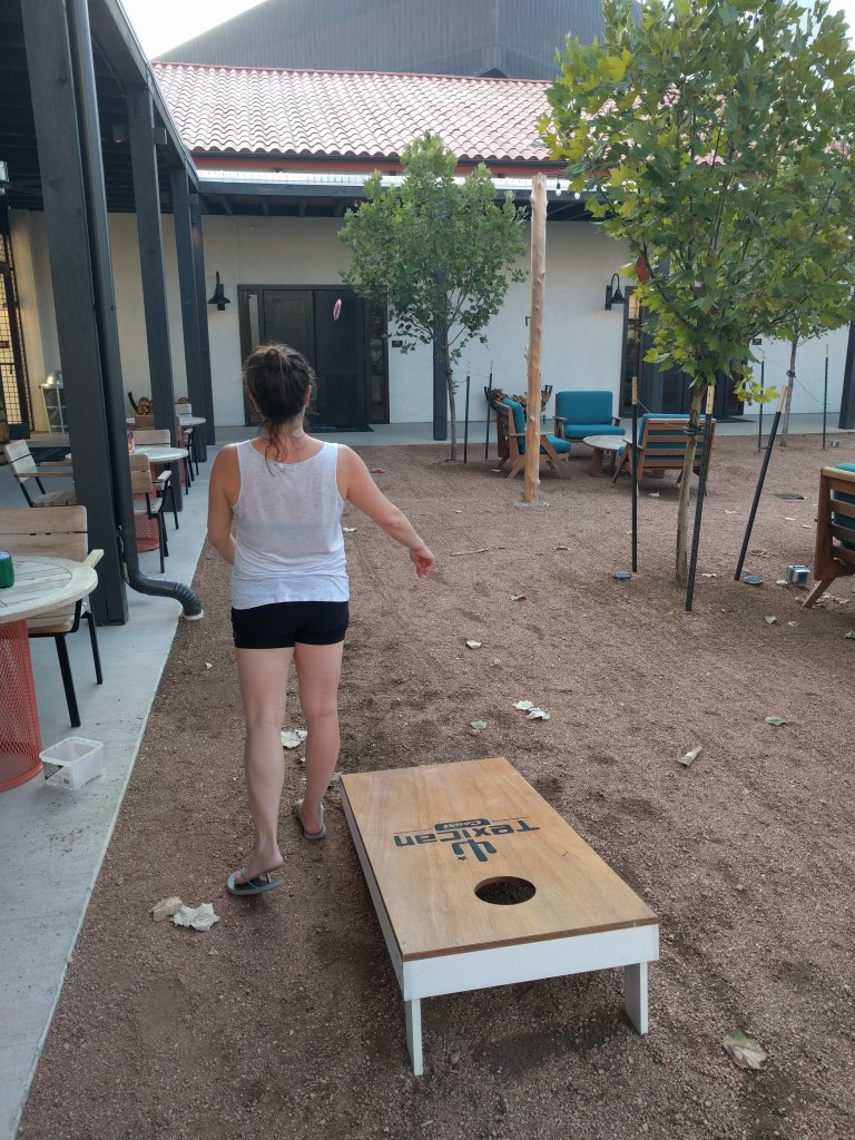 Max playing corn hole at Texican Court