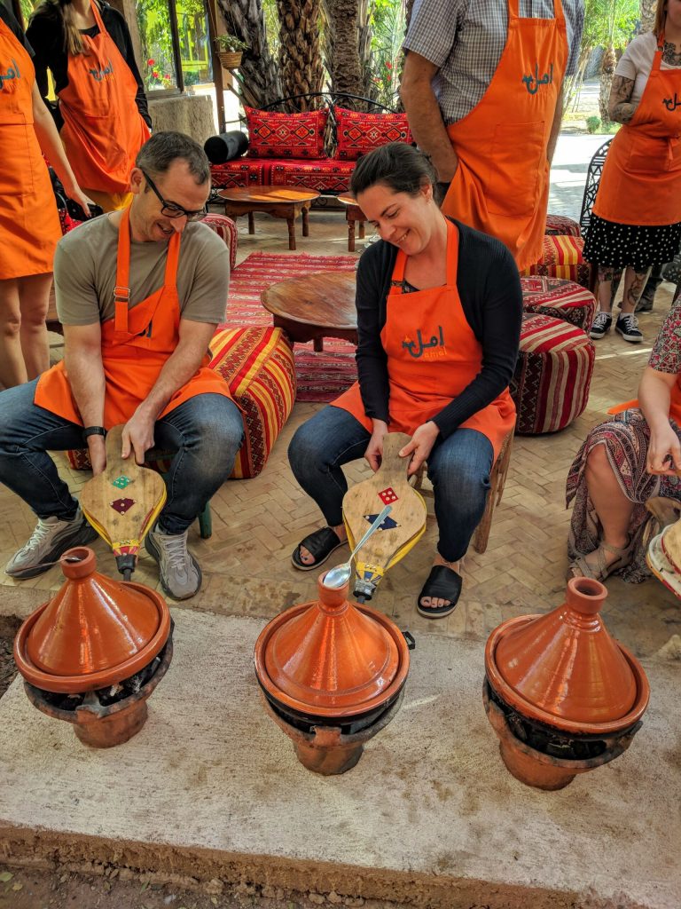 Adding air to the coals to get the fire going to cook our tajines at Amal Cooking Class