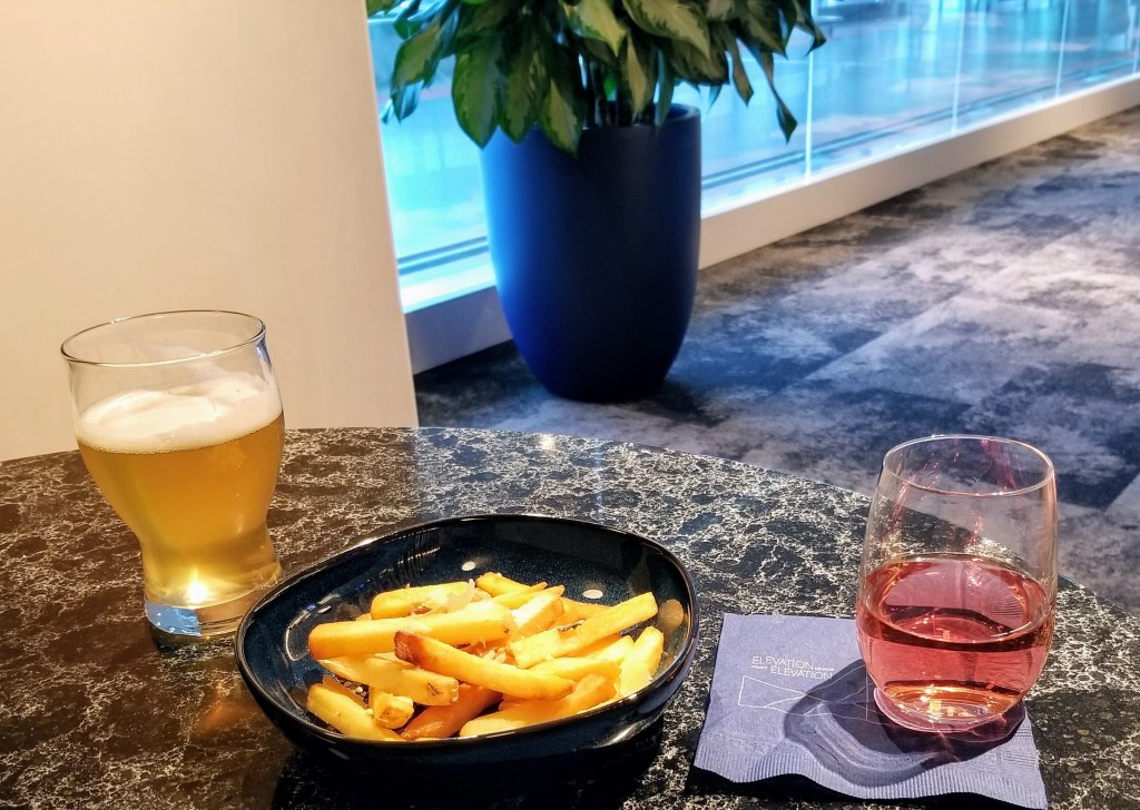 YYC WestJet Elevation Lounge: WestJet Elevation beer (left) and Road 13 sparkling rose (right) with truffle fries