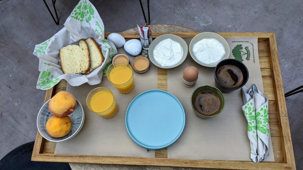 Monsieur Didot Room 6 - The ode to the light: Breakfast of Greek coffee, yogurt, orange juice, hard-boiled eggs, peaches, bread, butter, and honey