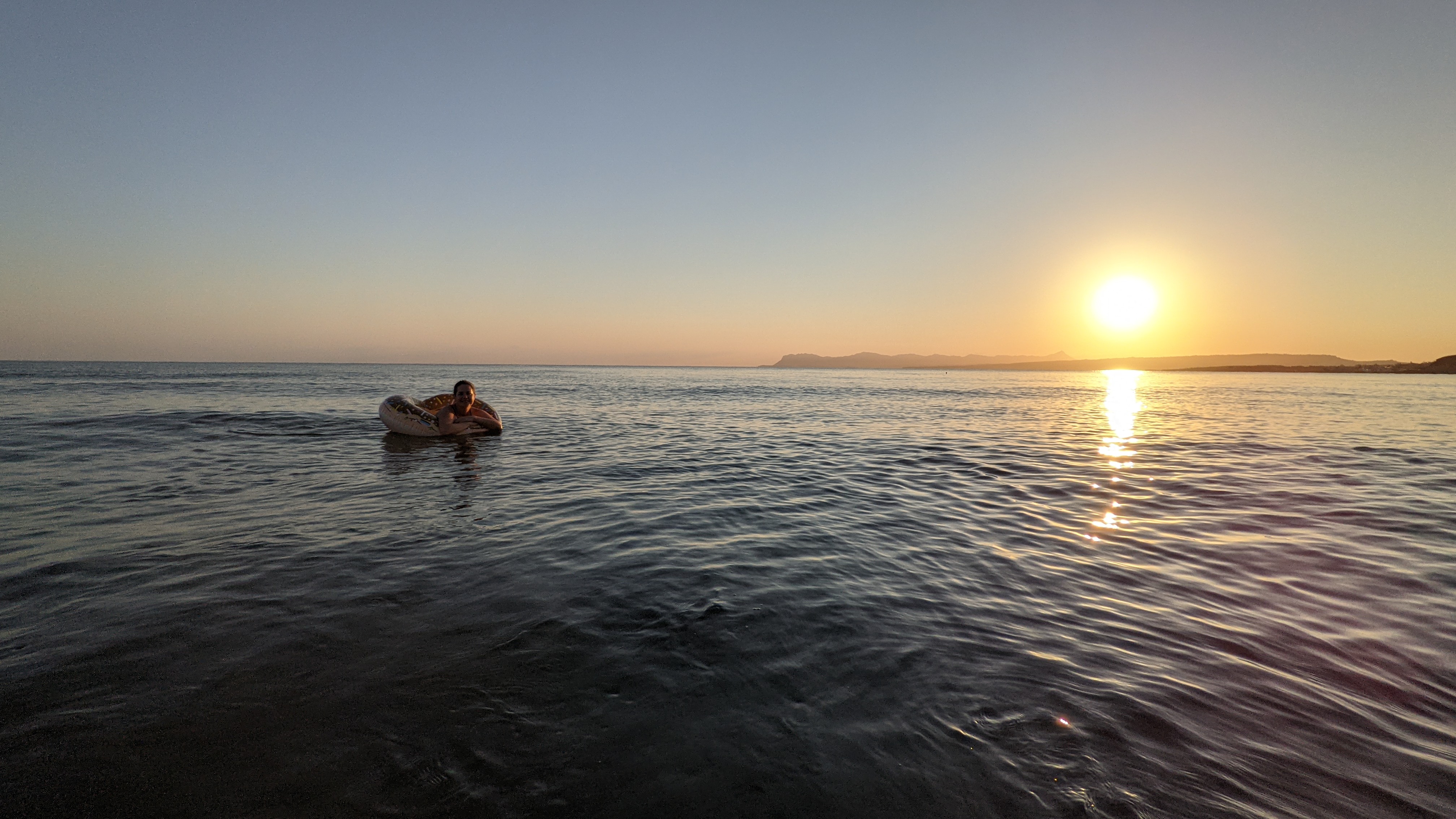Max floating in the sea at sunrise